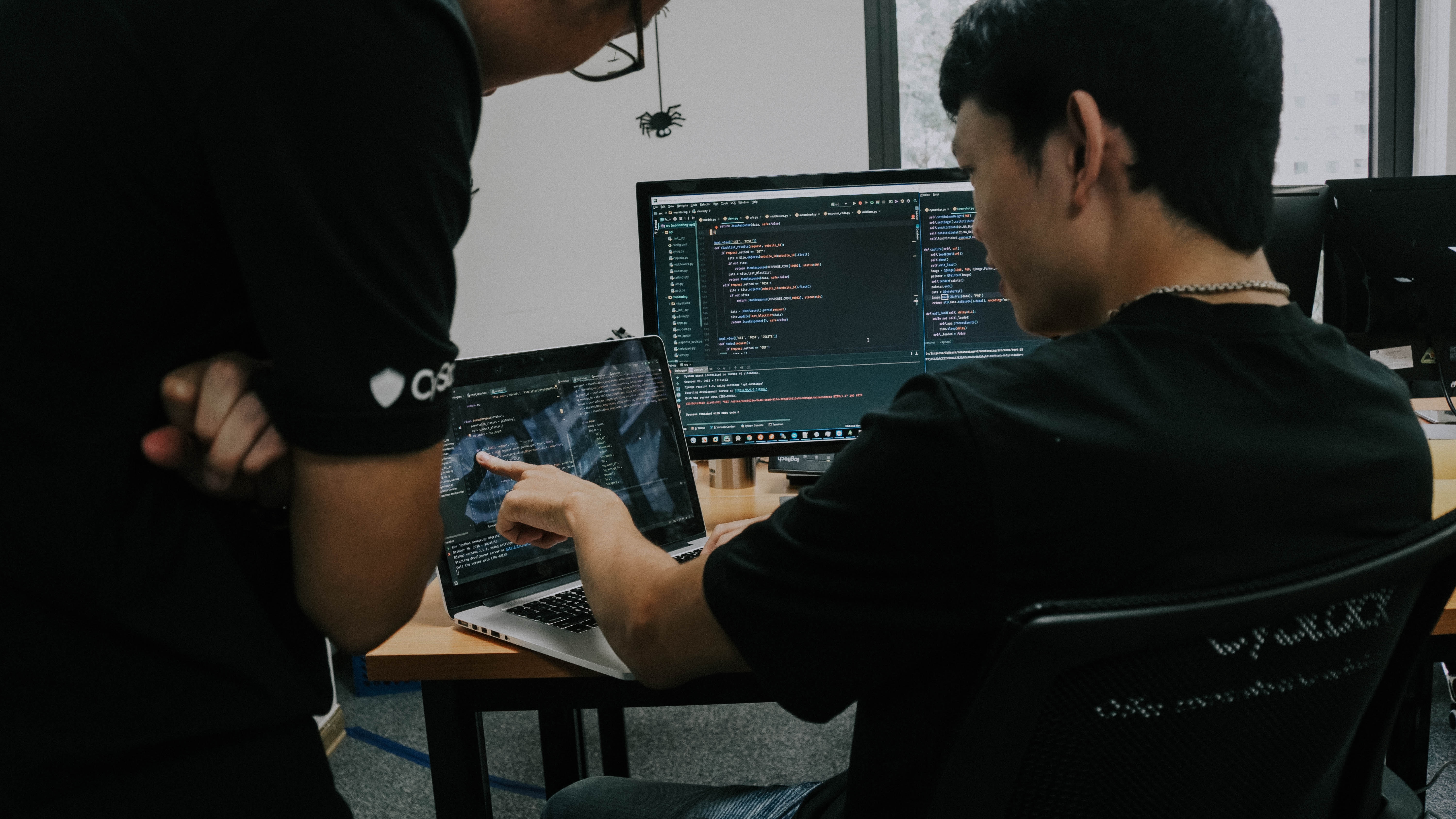 two men working on computers in an office photo