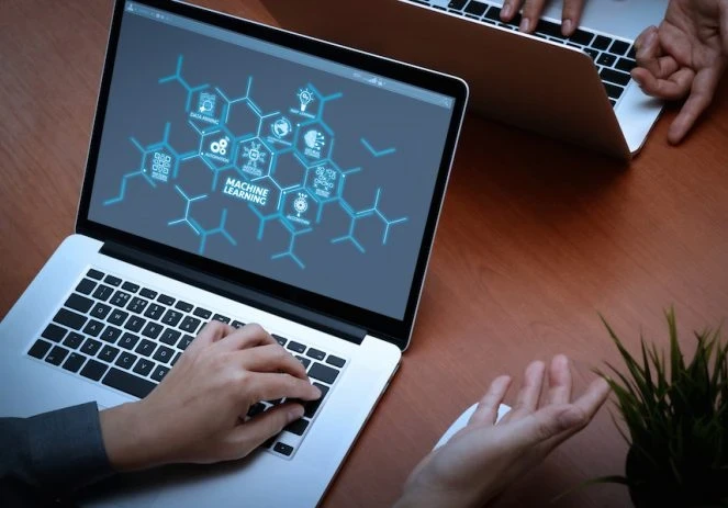 Someone working on a laptop with a mindmap with "machine learning" in the middle of the screen
