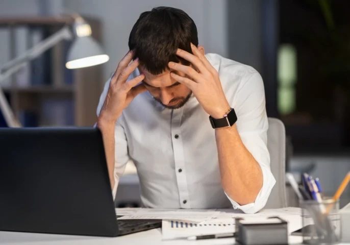 A frustrated man sitting at a computer