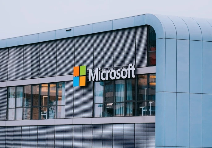 Closeup of big, grey office building with Microsoft logo displayed on the side.