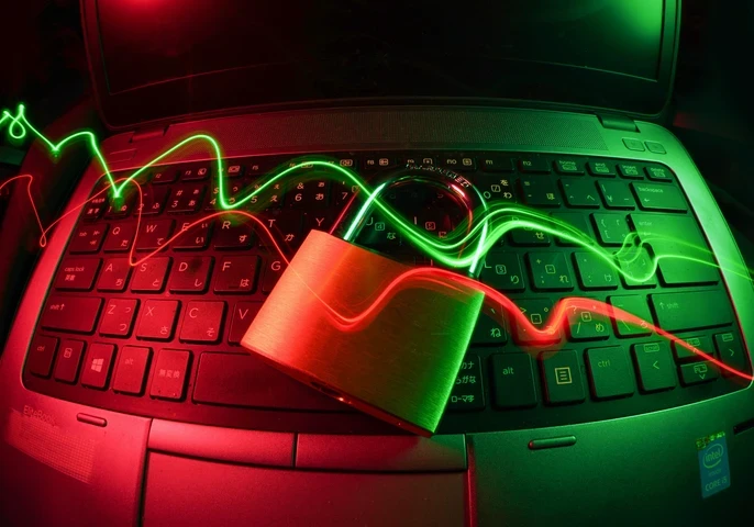 An image depicting a closed lock laying on a laptop keyboard with red and green swirls flowing across.