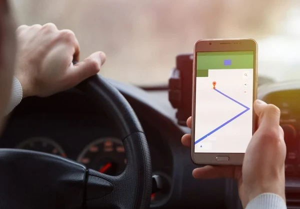 A person driving and using a smartphone map