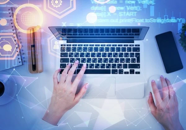 Person sitting at a desk and typing on a keyboard.
