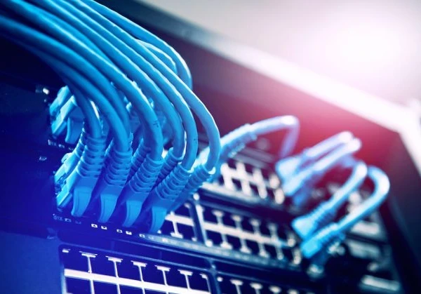 Image of IT cables in an IT server in blue and red lighting
