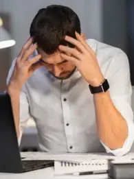 A frustrated man sitting at a computer