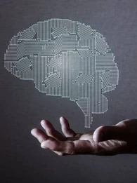 Decorative image of brain in computer chip styloating above hand