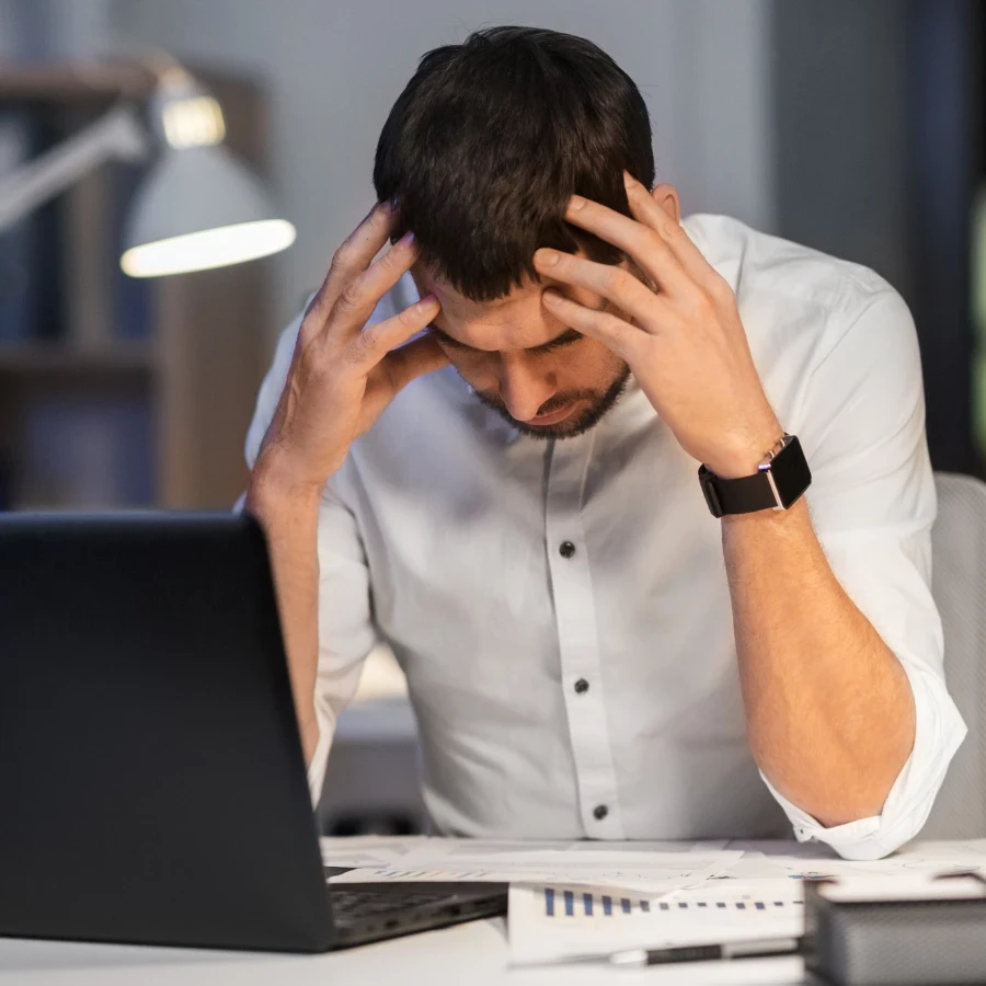 A frustrated man sitting at a computer