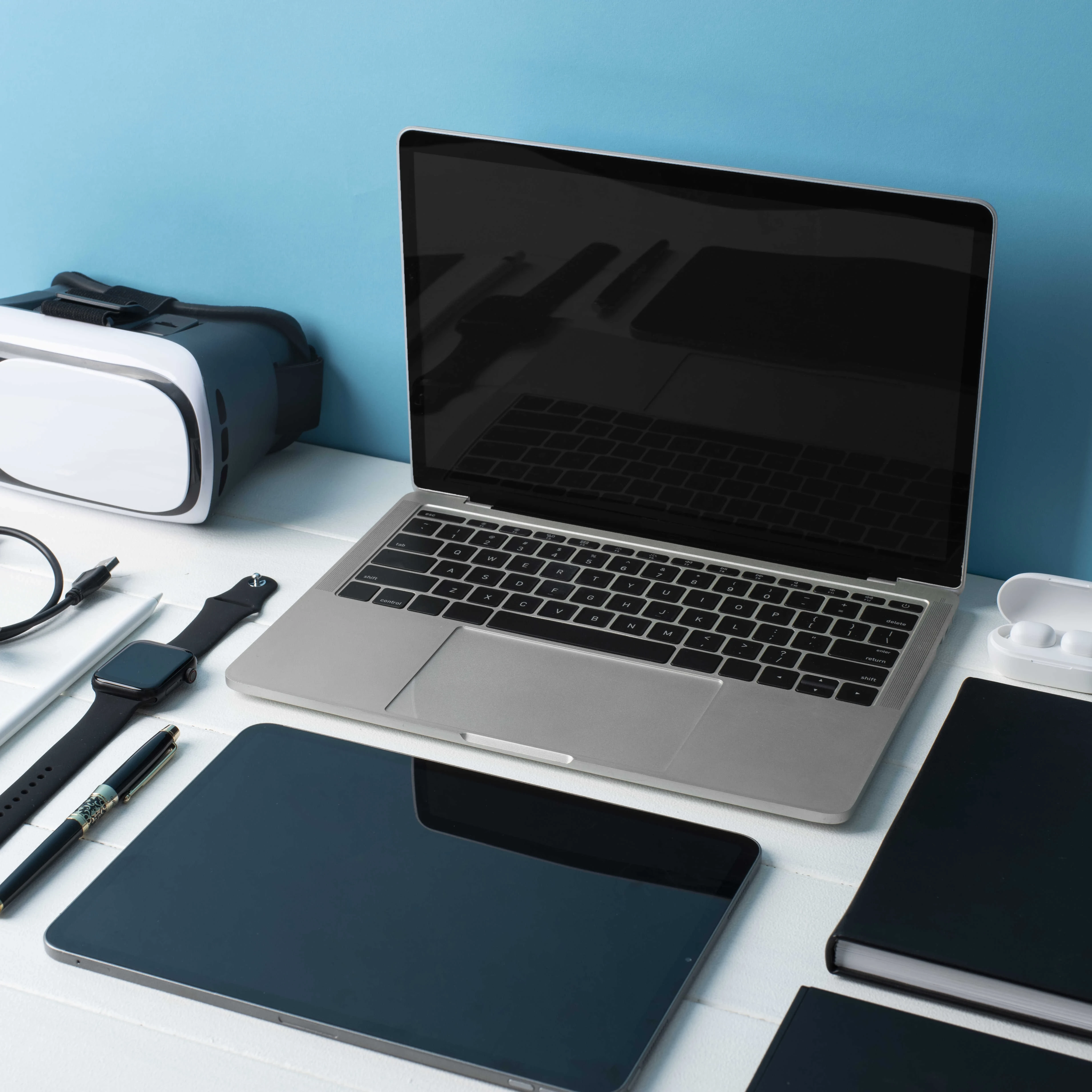Photo of various digital devices including laptop, tablet, smart watch, VR goggles and more