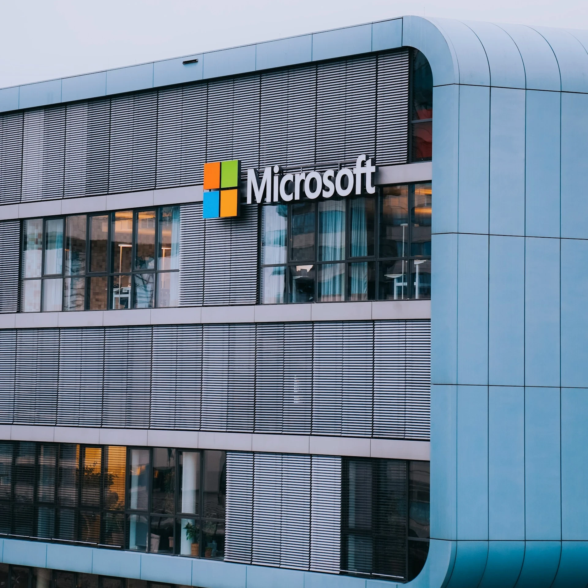 Closeup of big, grey office building with Microsoft logo displayed on the side.