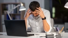 A frustrated man sitting at a computer